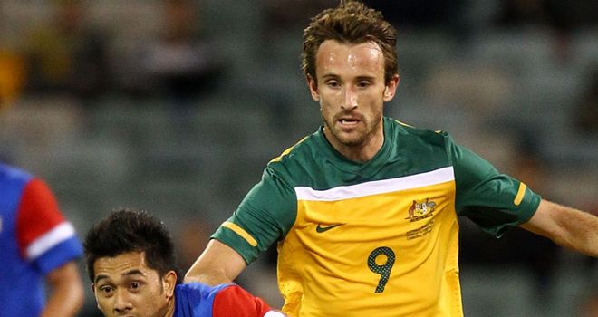 Josh Kennedy tangles for the ball in Australia's 5-0 win over Malaysia