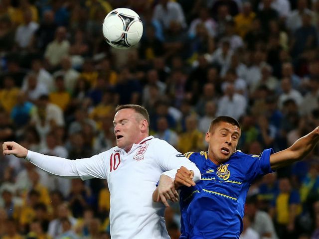 Rooney and Khacheridi go up for a header.
