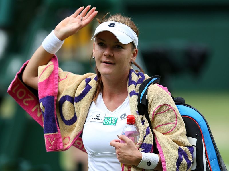 ... and waves to the Wimbledon crowd