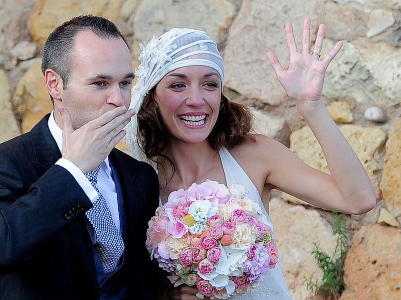 Andres Iniesta and his wife Anna Ortiz wave to the crowd after their wedding at the castle of Tamarit in Tarragona.