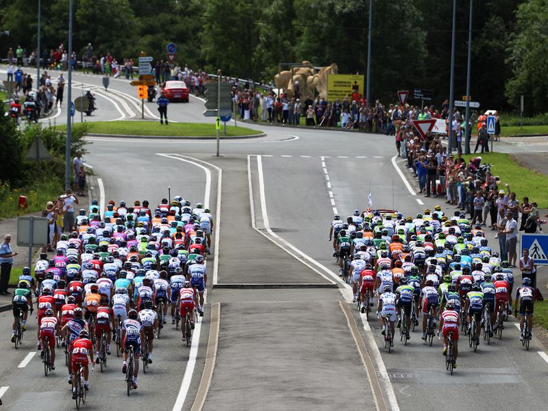 The bunch momentarily splits in two to avoid traffic furniture