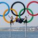 Australian gold medalists Mathew Belcher and Malcolm Page celebrate in the Olympic rings after their victory on the water.
