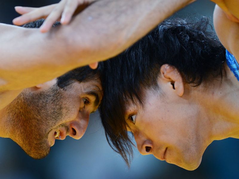 Ashraf Aliyev of Azerbaijan competes with Sohsuke Takatani of Japan in the men's freestyle 74 kg wrestling.