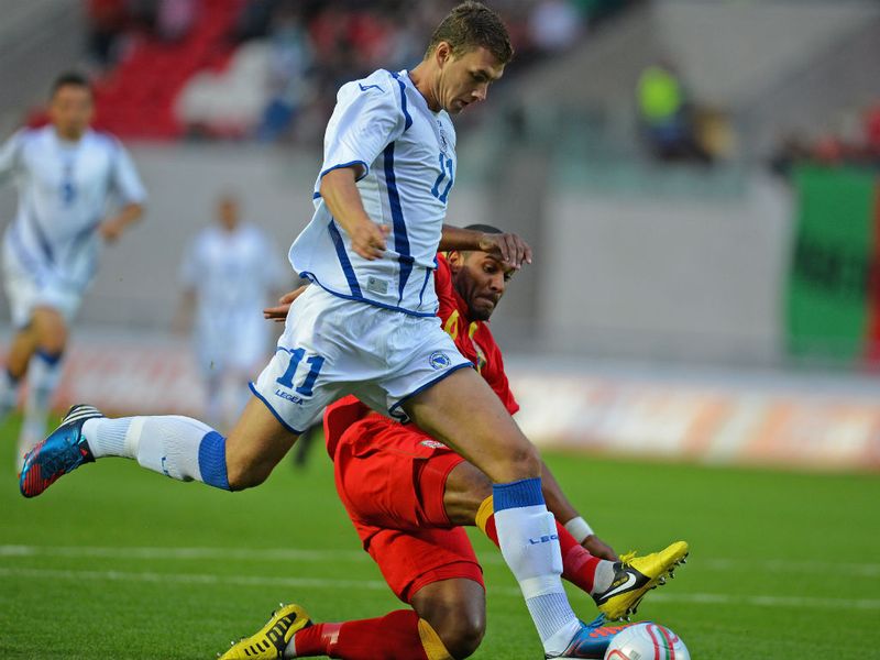 Bosnia striker Edin Dzeko vies with Joe Allen of Wales at Scarlets Park in Llanelli.