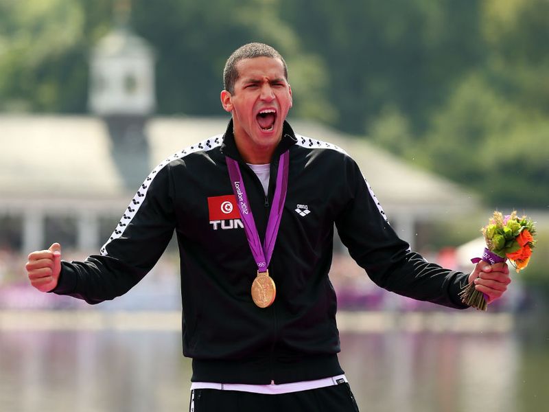 Tunisia's Oussama Mellouli celebrates with his gold medal following the men's marathon 10km swim.