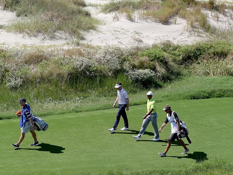 Tiger and defending champion Keegan Bradley stroll down 18.