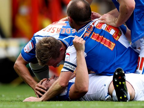 Scott Dann is mobbed after hitting the net