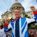 Team GB's long jump hero Greg Rutherford lifts his gold medal in front of St. Paul's Cathedral.