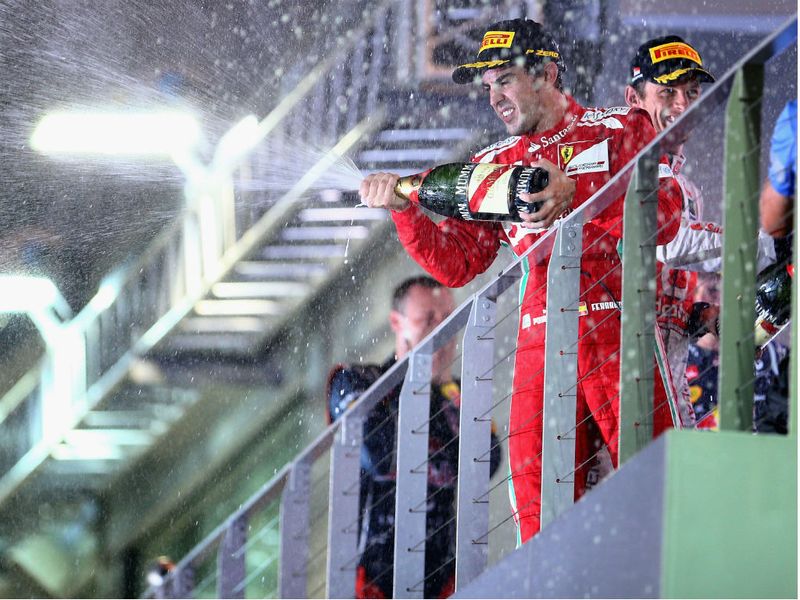 Alonso sprays the bubbly from the podium