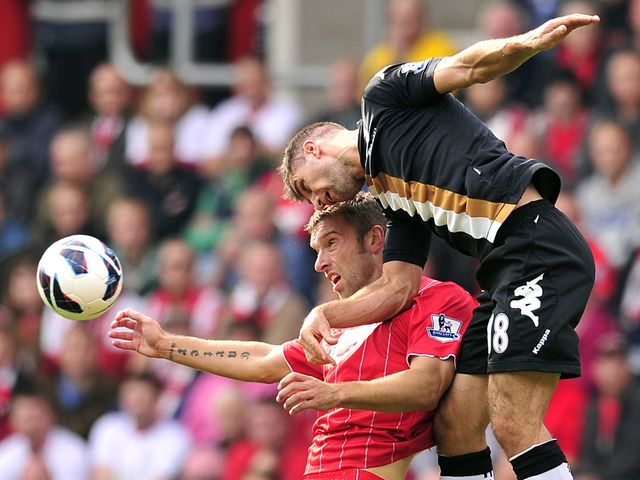 Hughes beats Lambert for a header.