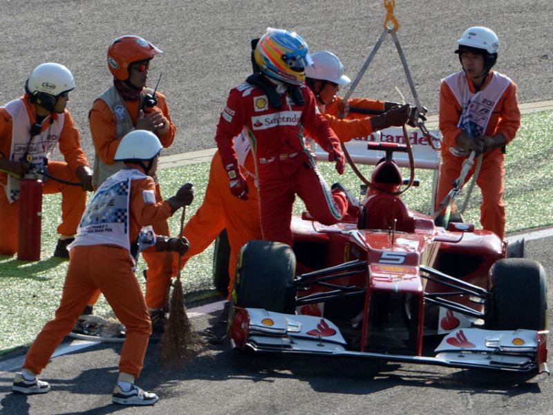 Fernando Alonso gets out of his car after the turn 1 crash