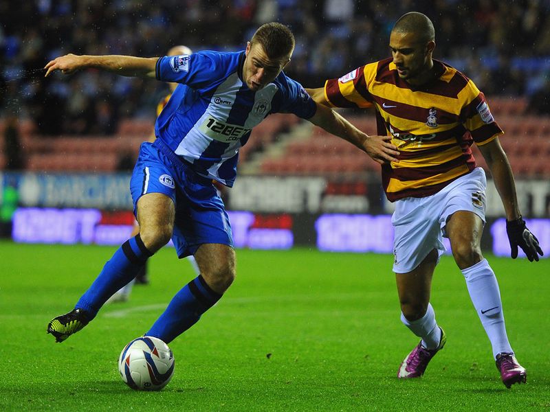 Latics frontman Callum McManaman tries to keep Bradford's James Meredith at bay.