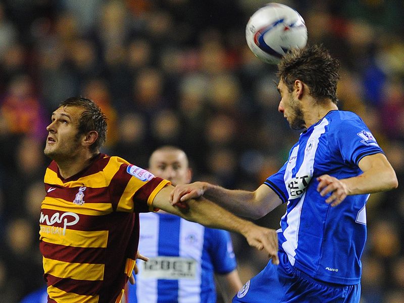 Bradford's James Hanson vies for the ball with Wigan defender Piscu at the DW Stadium.