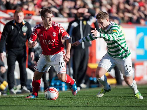 Niall McGinn and Kris Commons battle for the ball