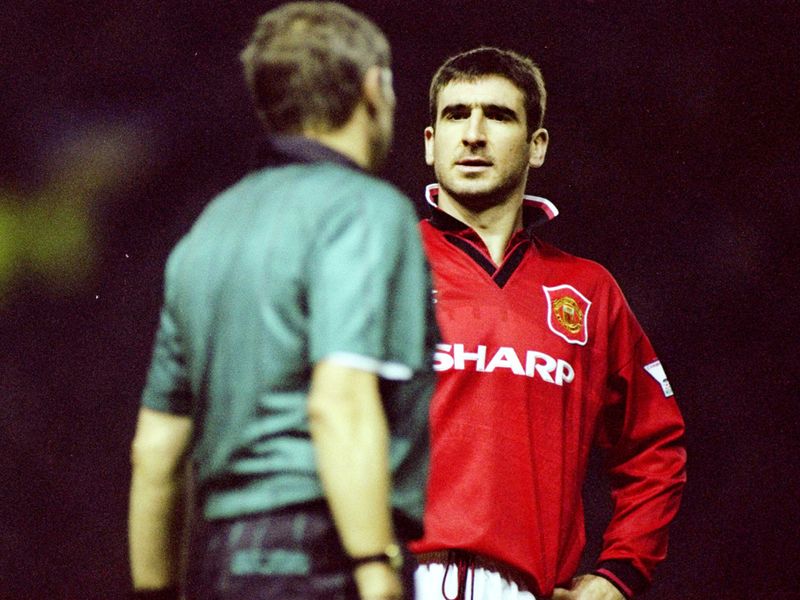 Cantona argues with the referee with his infamous upturned collar on display.