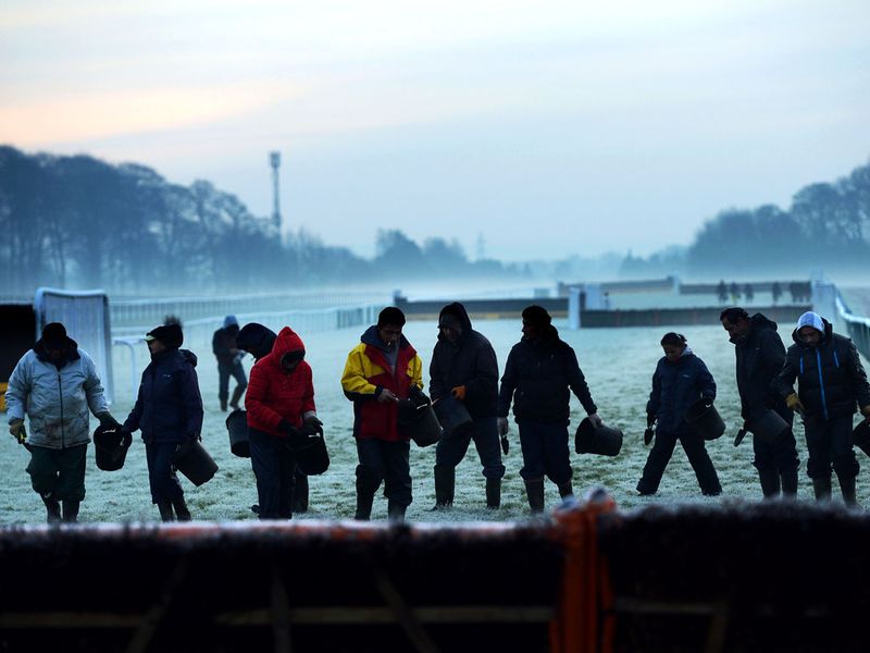 Out on the track the groundstaff go to work amid fog and frost