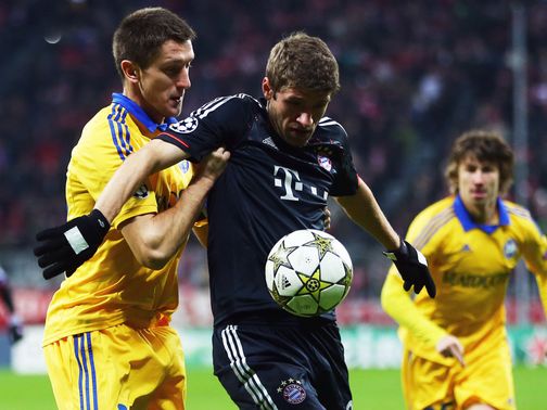 Artem Radkov and Thomas Muller battle for the ball