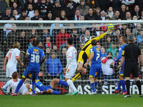 Jon Otsemobor scores MK Dons' late winner against AFC Wimbledon.