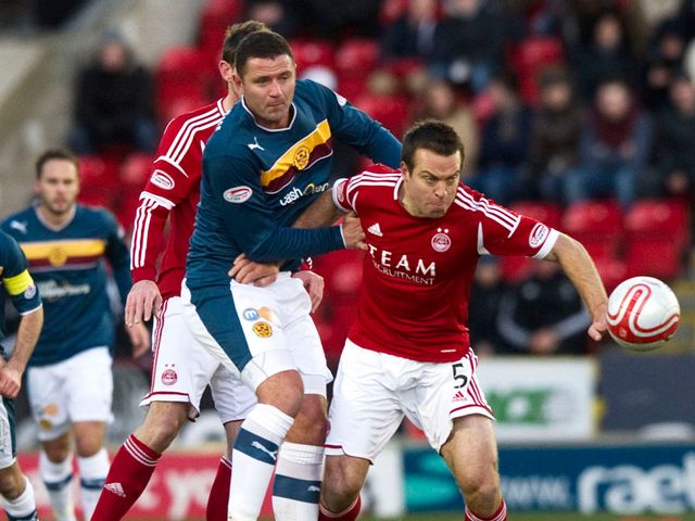 Michael Higdon battles for the ball with Gavin Rae