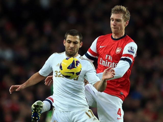 Itay Shechter holds off Per Mertesacker
