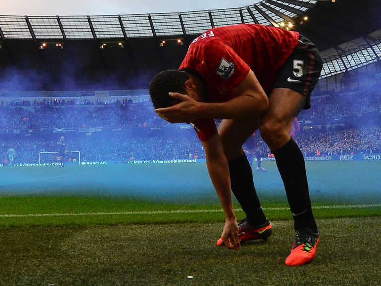 Rio Ferdinand grabs his head after being struck