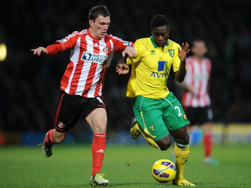 Craig Gardner and Alex Tettey tussle for the ball in the early stages at Carrow Road