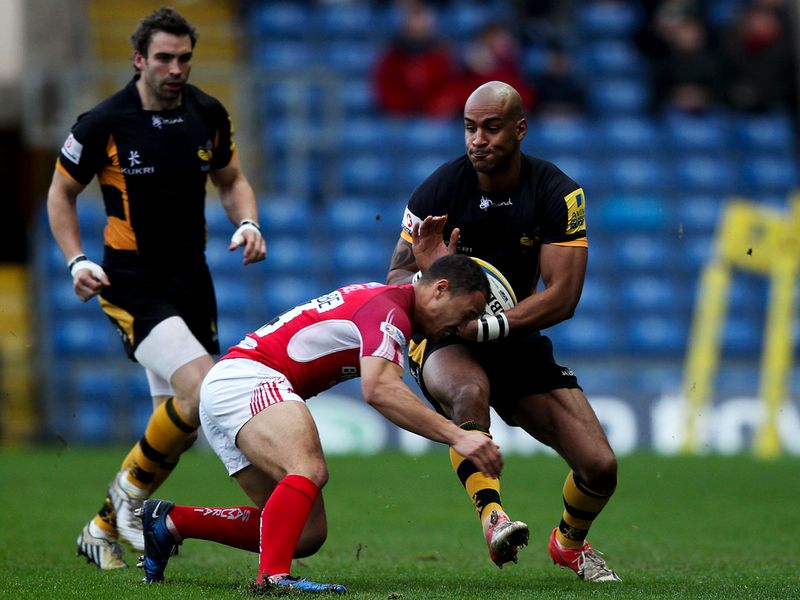 Giving their all: Tom Varndel of Wasps is tackled by Dan Caprice