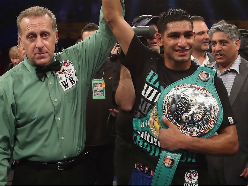 Amir's hand is raised by referee Jack Reiss as he clutches the WBC 'silver' title