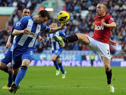 Gary Caldwell and Tom Cleverley go for the ball