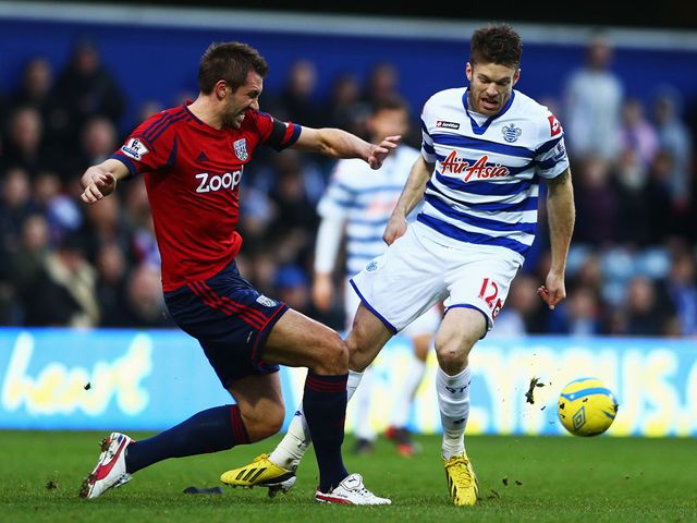 Gareth McAuley and Jamie Mackie compete for the ball