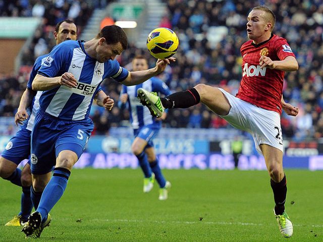 Gary Caldwell and Tom Cleverley go for the ball