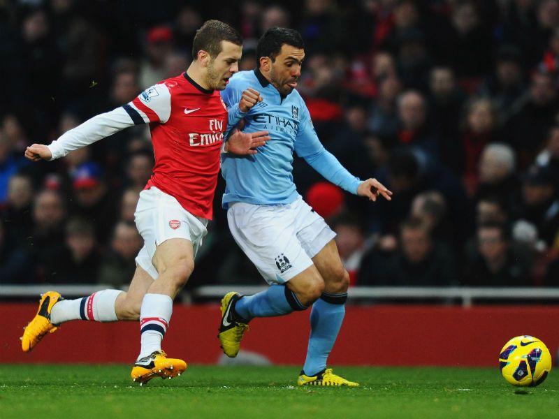 Game on: Carlos Tevez battles with Jack Wilshere early on at the Emirates as Manchester City look to beat Arsenal and close the gap at the top of the table
