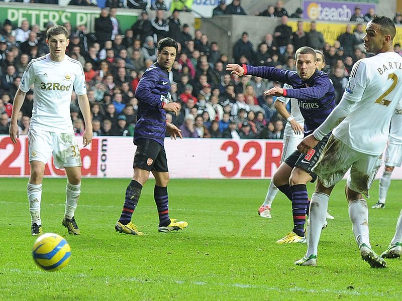 Swansea get a bit sloppy in possession and Arsenal make their pressure pay off. Lukas Podolski pounces on a loose ball on the area...