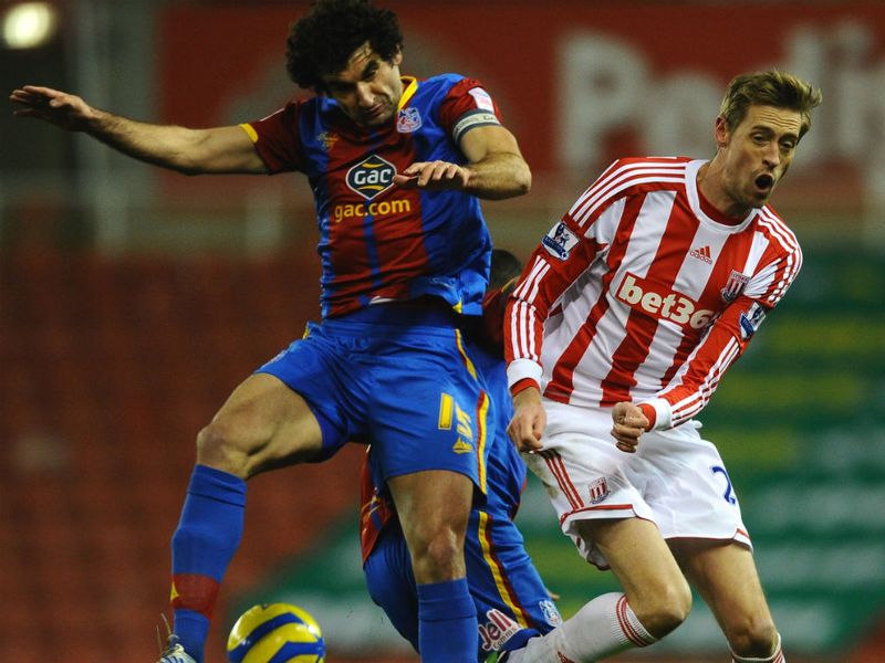 Mile Jedinak and Stoke's Peter Crouch are not quite sure where the ball is as they clash in the air