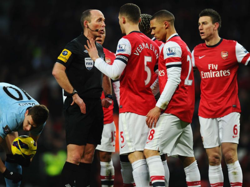 Come on ref! Thomas Vermaelen of Arsenal protests to referee Mike Dean as Laurent Koscielny (right) is sent off...
