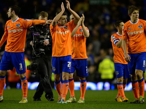 Oldham players applaud their fans after defeat at Everton