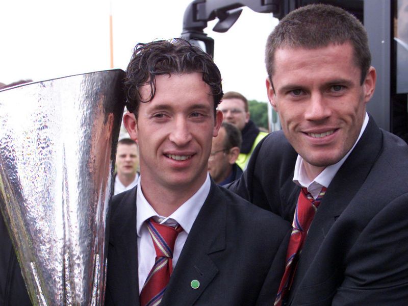 Carragher holds the UEFA Cup with Robbie Fowler after completing the treble in 2001