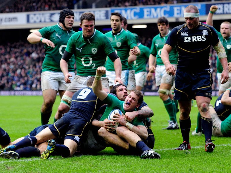 Gilroy celebrates his try by raising his right-hand in the air