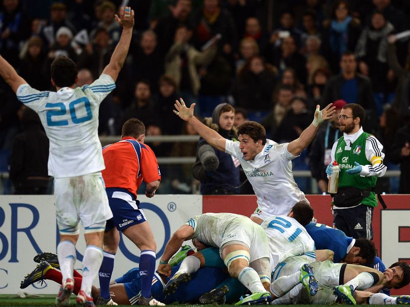 Wild celebrations: Italy's players hold their hands in delight at the final whistle as they beat France