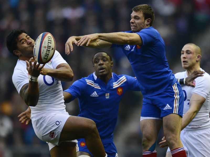 France wing Vincent Clerc competes for the ball with England centre Manu Tuilagi