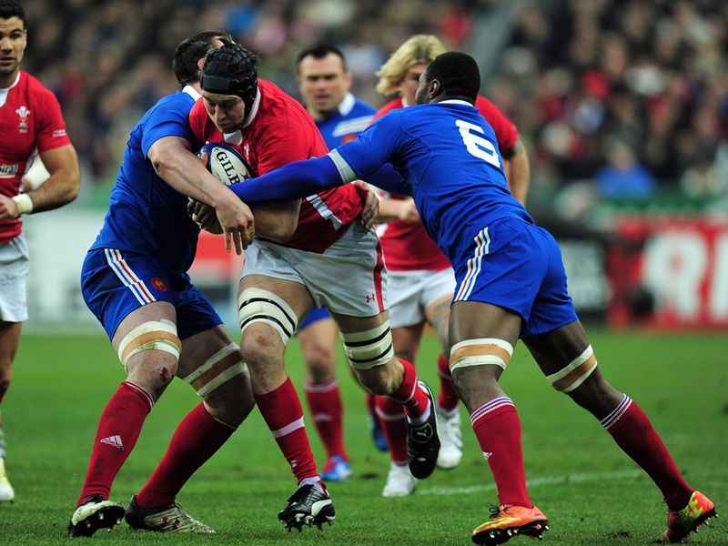 Double tackle: Ryan Jones tries to burst past two blue shirts