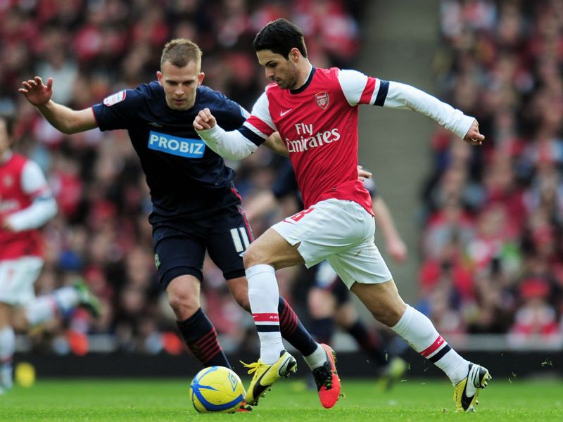 Mikel Arteta in full stride under the watchful eye of Jordan Rhodes