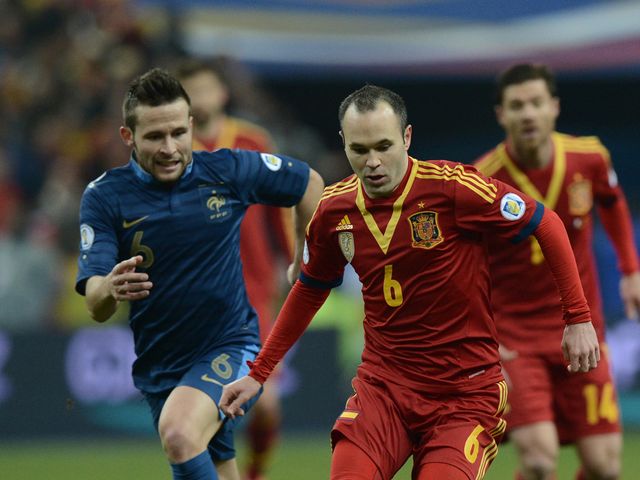 Andres Iniesta holds off France's Yohan Cabaye