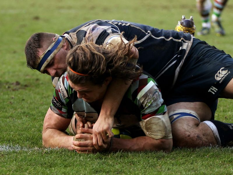 Leading from the front: Harlequins skipper Luke Wallace ducks through the tackle from Tom Holmes to score his side's fourth try