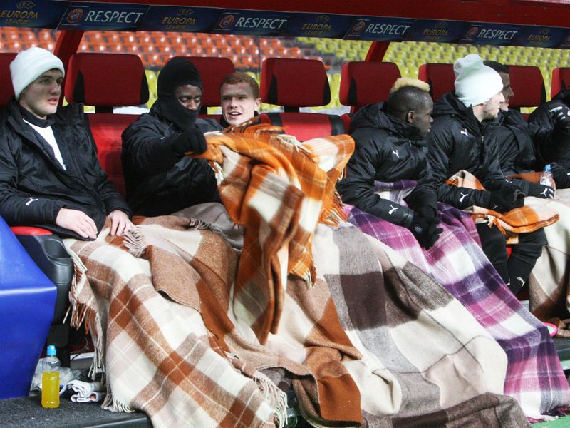The Newcastle substitutes try to keep warm on a freezing night in Moscow