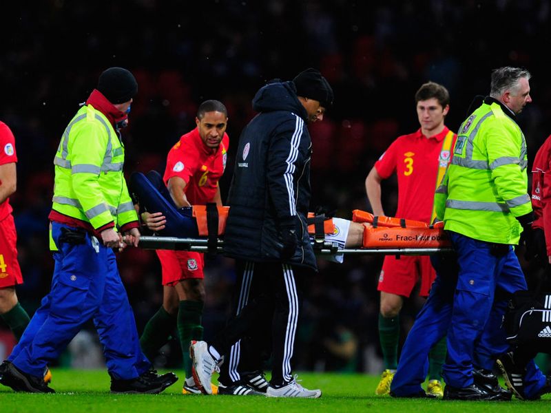 Steven Fletcher is stretchered off after a minute in Scotland's clash with Wales after landing awkwardly.
