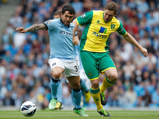 Carlos Tevez holds off Grant Holt