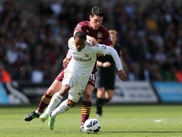 Jonathan de Guzman and Gareth Barry battle for the ball.