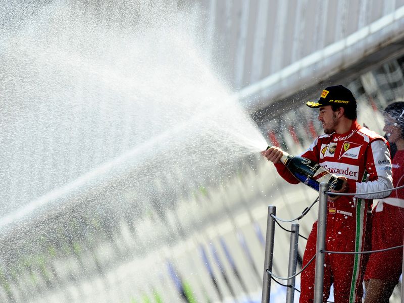 Fernando Alonso soaks the crowd below the podium