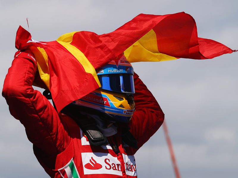 Fernando Alonso celebrates with the Spanish flag